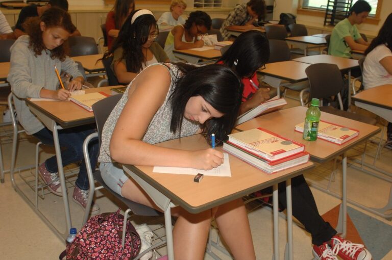 Collégiens en classe en train d'écrire sur une copie, illustration du calcul de moyenne au collège
