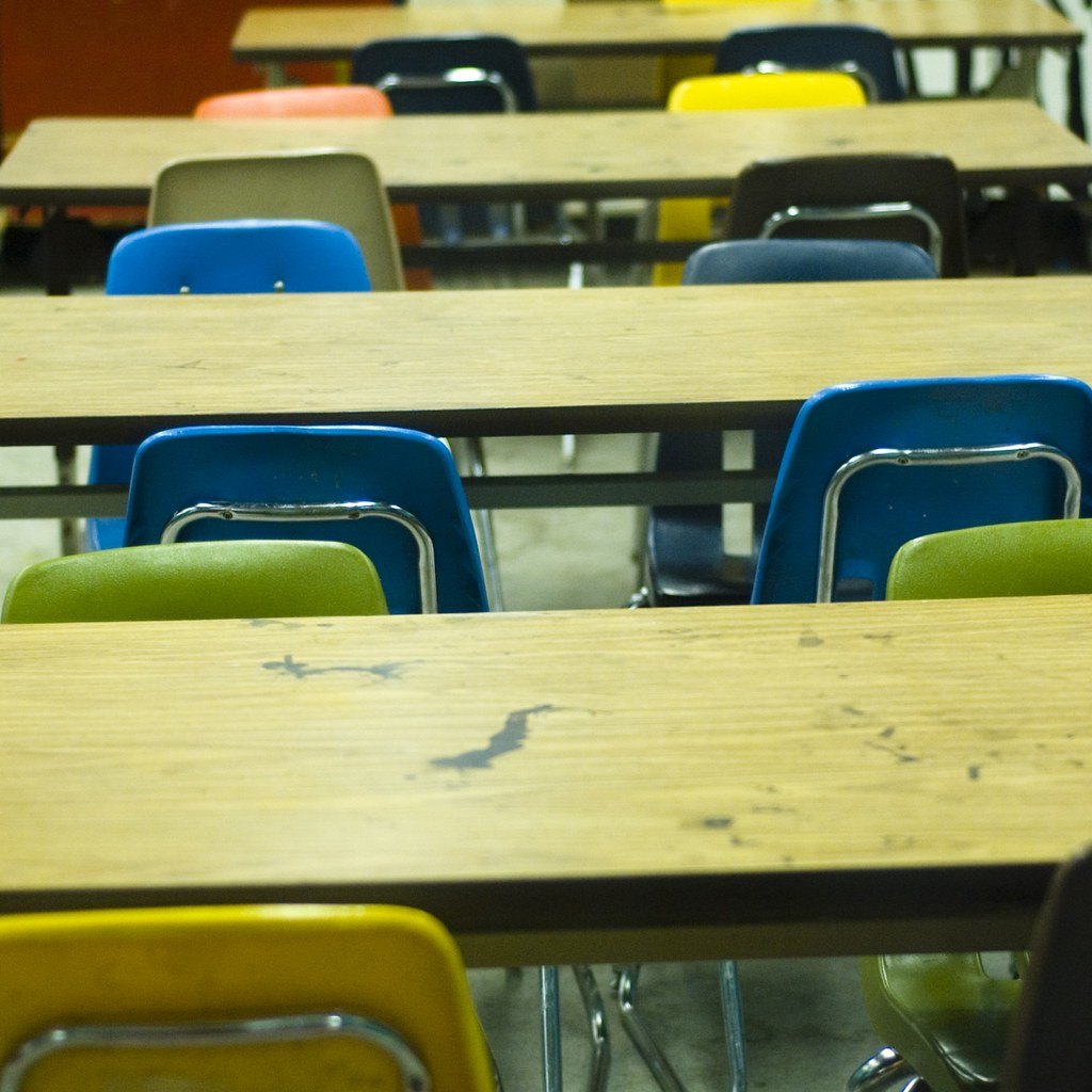 Salle de classe vide avec chaises colorées, symbole du passage au bac en terminale