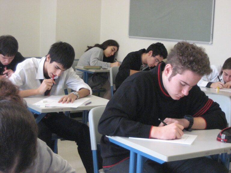 Élèves en salle d'examen écrivant leur copie, pour calculer sa moyenne au brevet 2026 selon la formule officielle