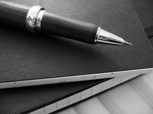 Stylo posé sur des carnets, illustrant le poids du contrôle continu dans la note finale du brevet